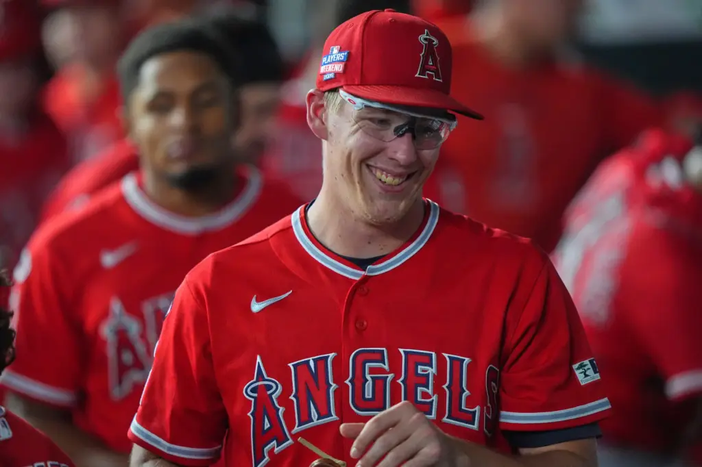 Angels starting pitcher Ryan Johnson smiles in the dugout after...