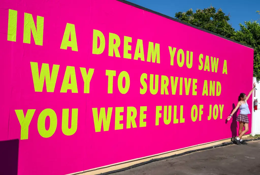 A festivalgoer poses in front of an art installation by...