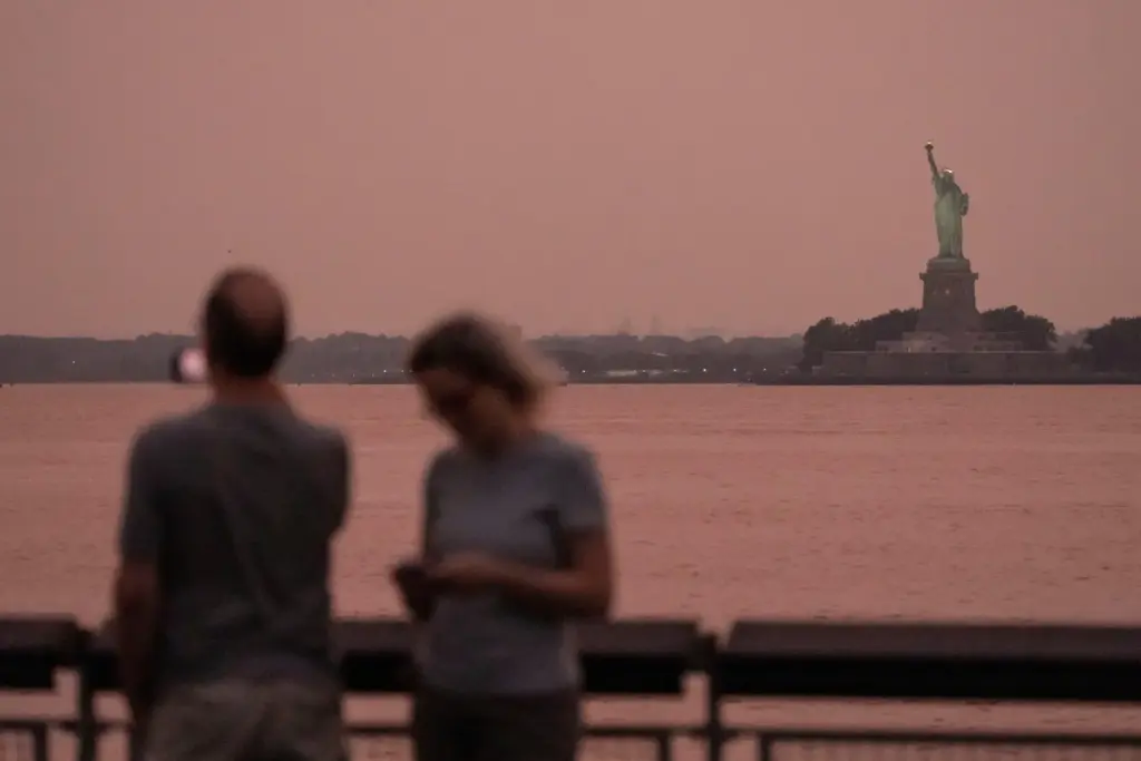 The Statue of Liberty is visible through haze due to Canadian wildfire smoke.