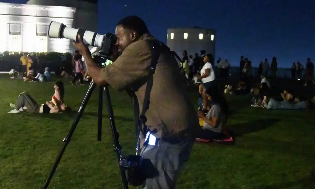 Clouds almost interfered as news photographer Jason Armond takes photos...