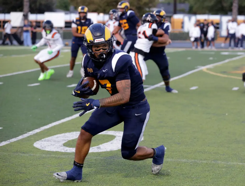 Millikans Ryan Carter (7) looks to gain yards for the...