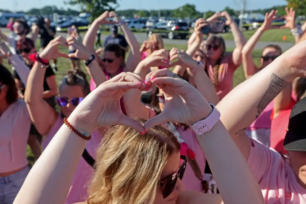 Supporters of Lindsay Clancy hold up heart symbols as they stand outside the Plymouth Courthouse.