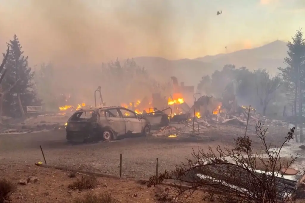 This image taken from video shows a charred neighborhood following...