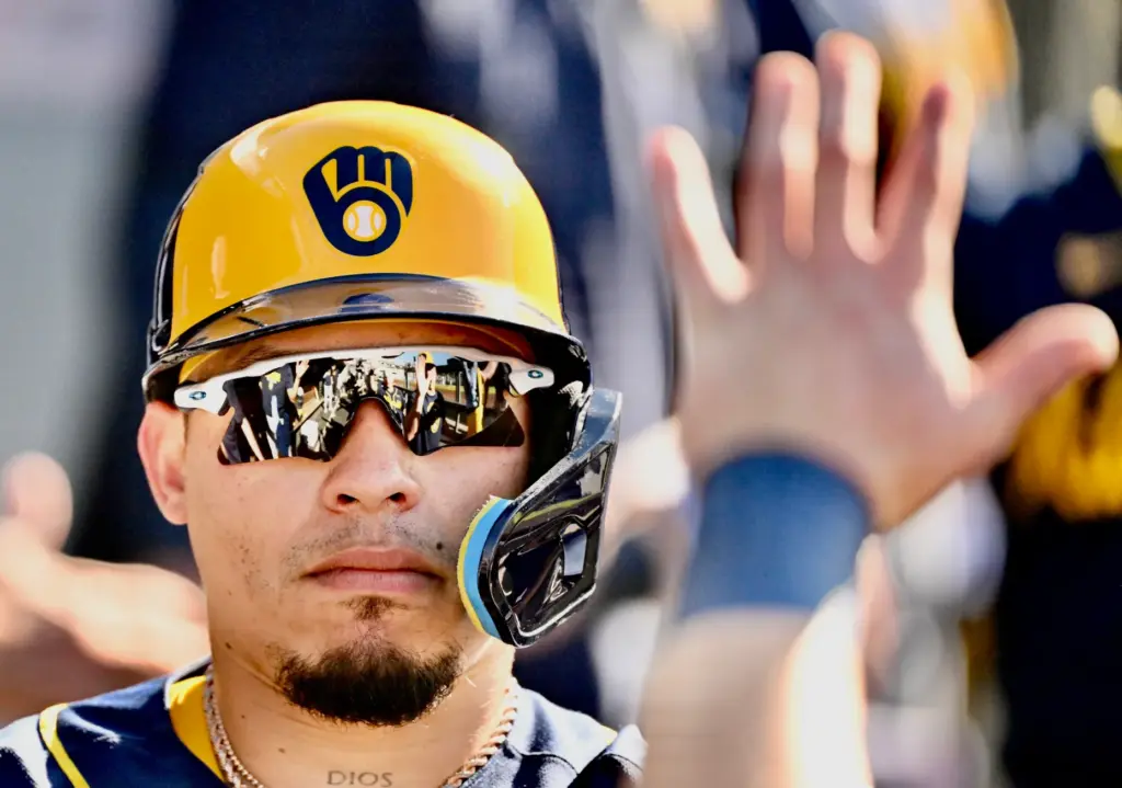 William Contreras of the Milwaukee Brewers high fives teammates after...