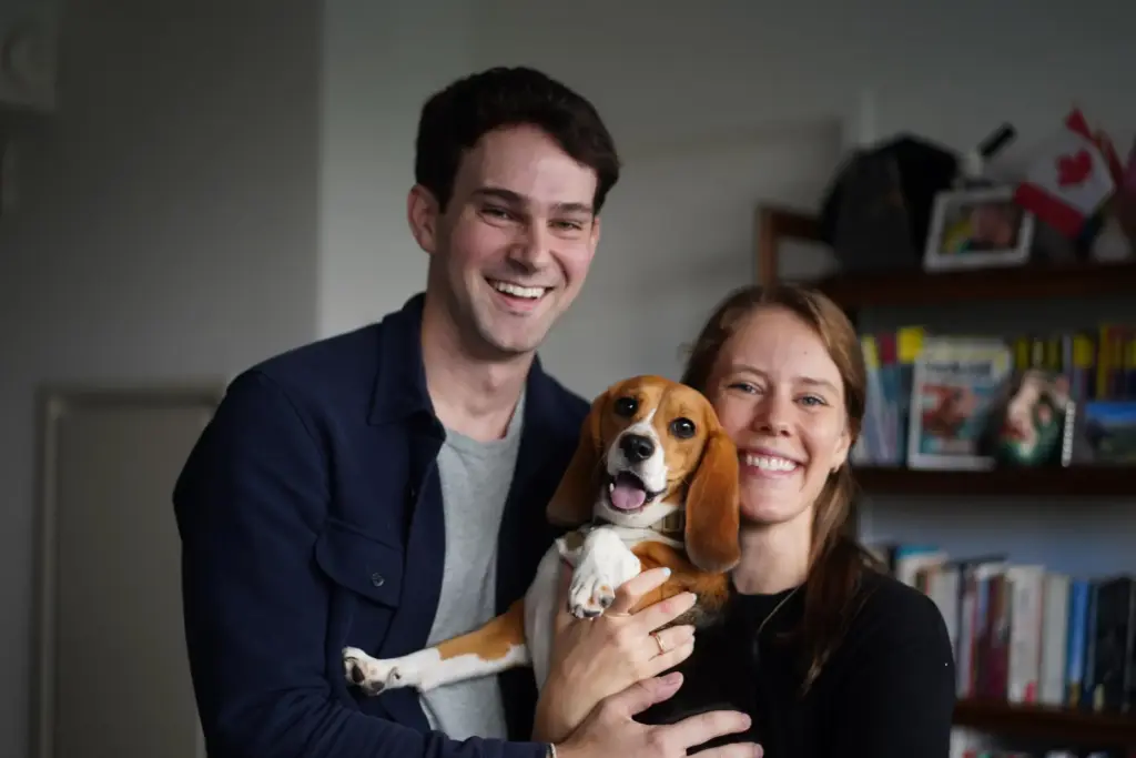 Matt and Maggie Walker pose for a photo with their gene-edited hypoallergenic beagle, Bailey.