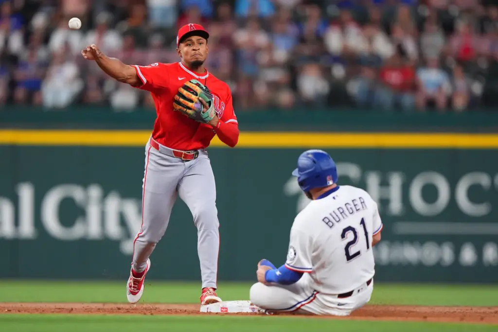 Angels second baseman Christian Moore, left, throws from second to...