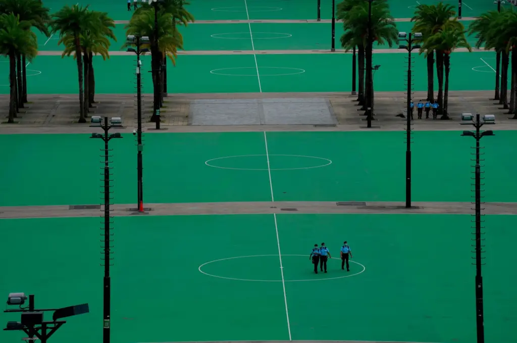 Police officers patrol an empty Hong Kong Victoria Park.