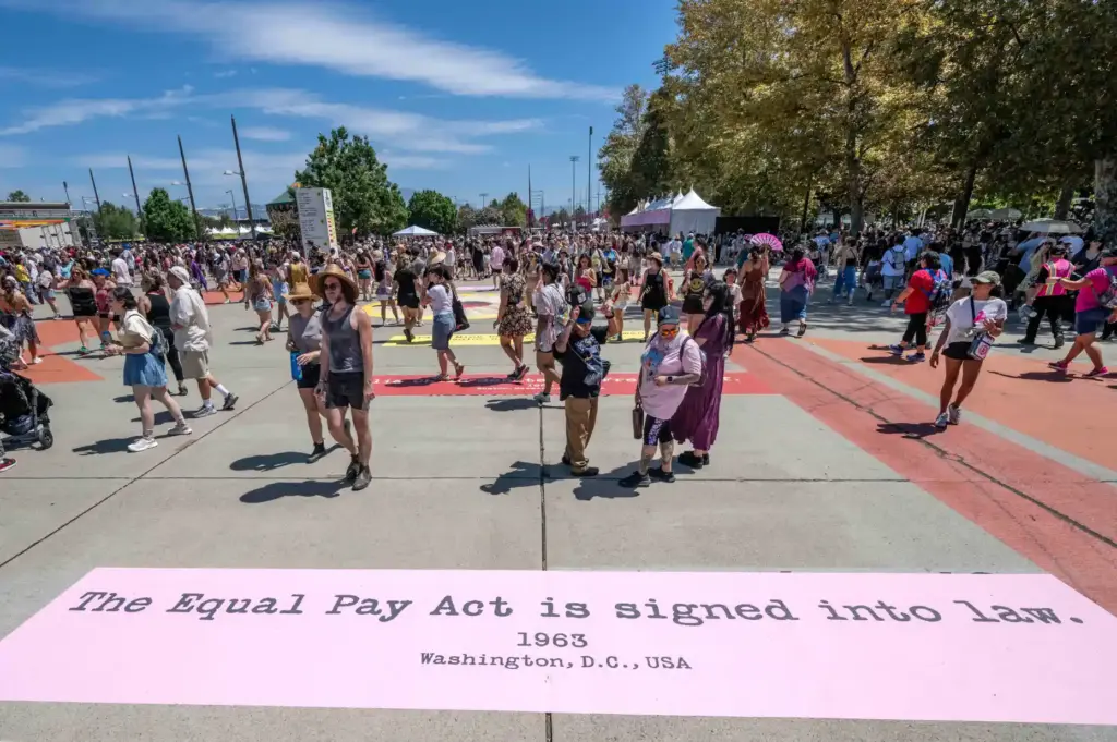 Festivalgoers walk along the Daisy Lane activation, featuring a timeline...