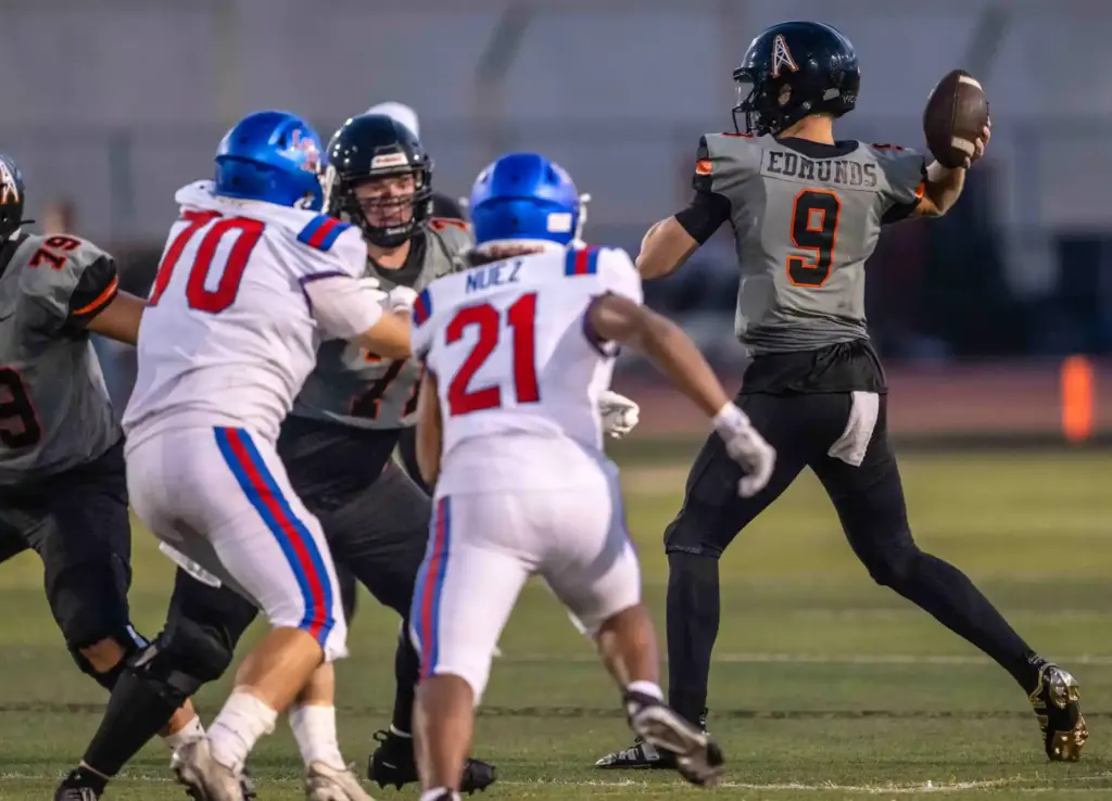 Huntington Beach quarterback Brady Edmunds (9) winds up to throw...