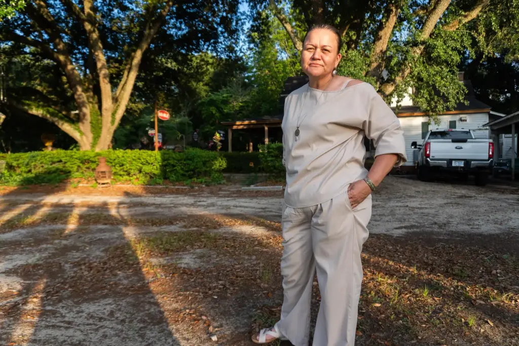 Angie Lowery, a citizen of the Lumbee Tribe, stands outside her home.