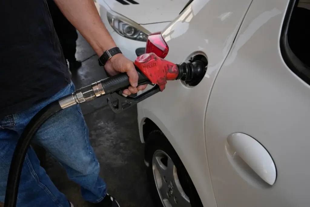 A man is filling up his car at a gas...
