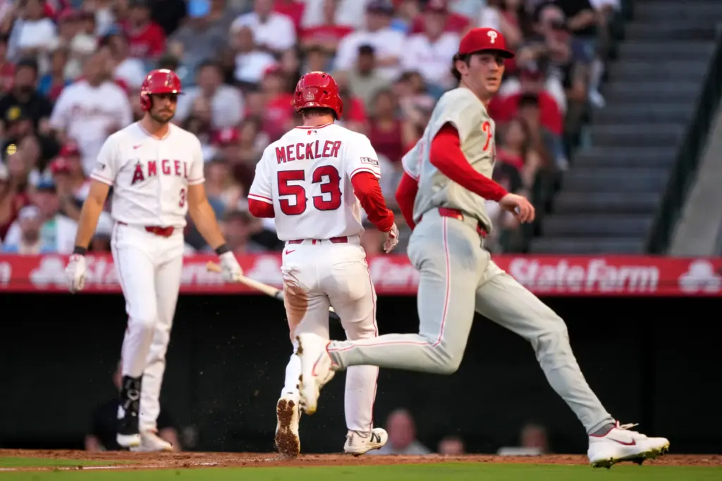 The Angels’ Wade Meckler, center, scores on a wild pitch...