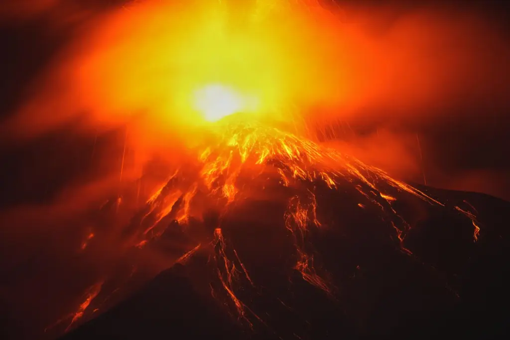 Lava flows out of the crater of the Fuego Volcano,...
