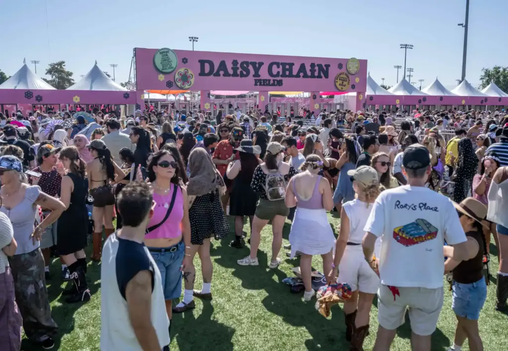 Thousands of festivalgoers line up outside the gates before the...