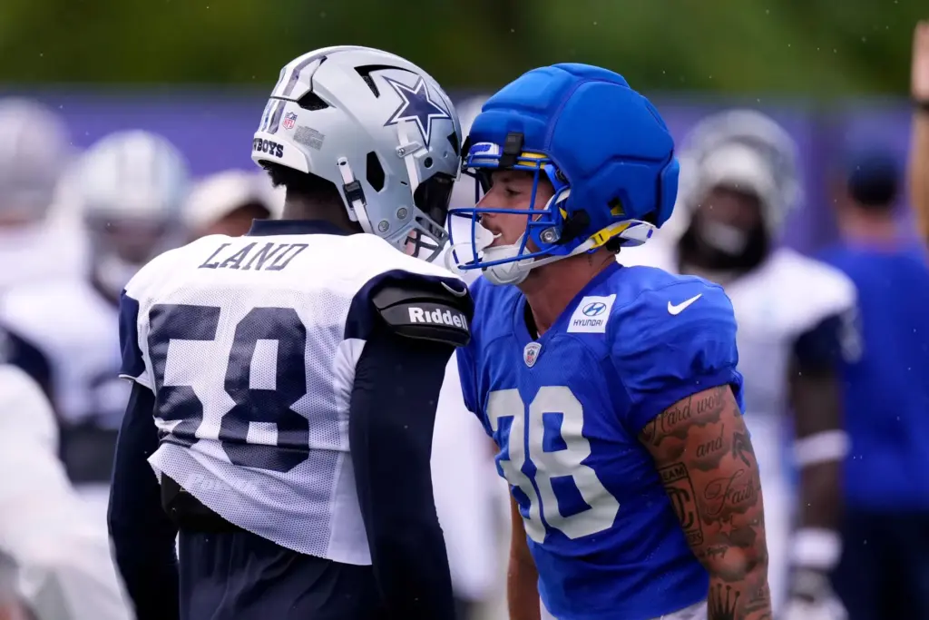 Dallas Cowboys outside linebacker Isaiah Land, left, and Rams tight...