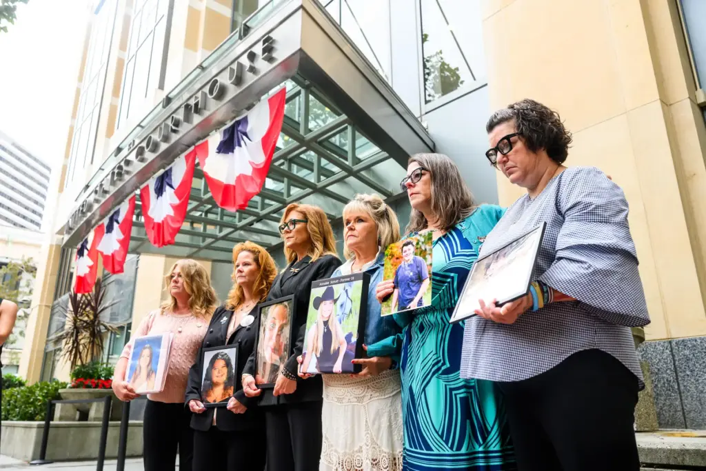 Parents hold pictures of their deceased children during a protest...