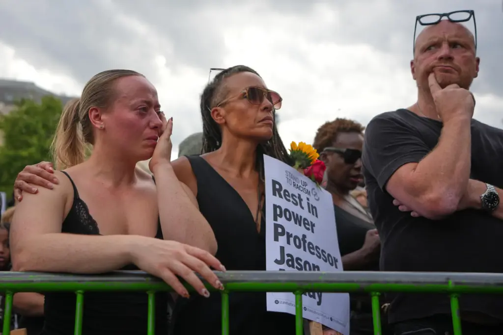 People attend a vigil held by Stand Up to Racism...