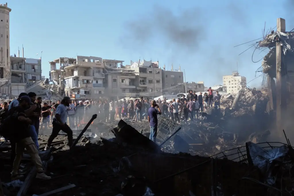 Palestinians inspect the rubble of a building destroyed in an...