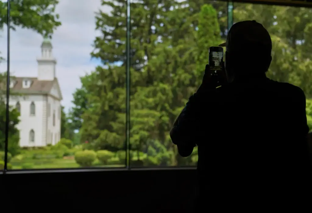 A visitor takes a photo of the Kirtland temple, a...