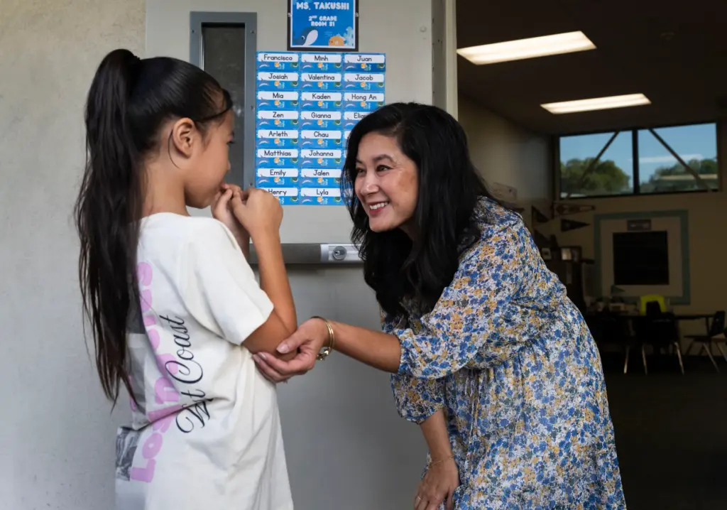 Gianna Plata is greeted by her second-grade teacher Irene Takushi...
