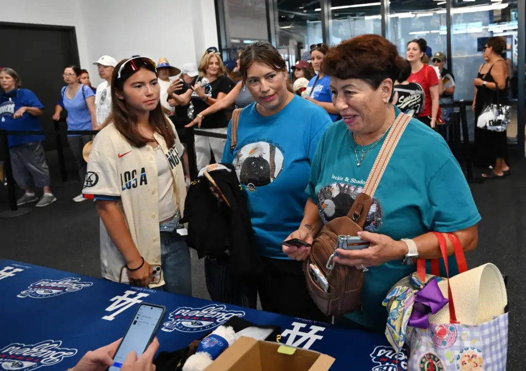 Mia Lopez, Christine Lopez, and Rose Fernandez buy commemorative t-shirts...