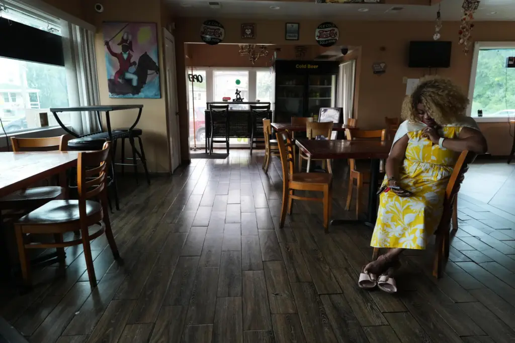 Marjorie EstimÃ© waits for a food order at the Caribbean Creole CafÃ©.
