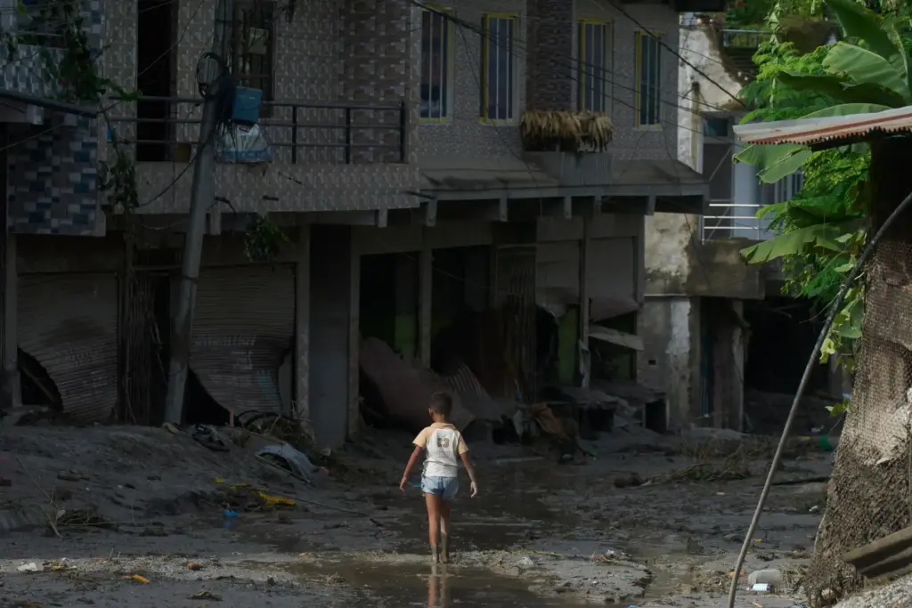 A child walks in mud in the aftermath of a flash floods in Devighat, Nepal.