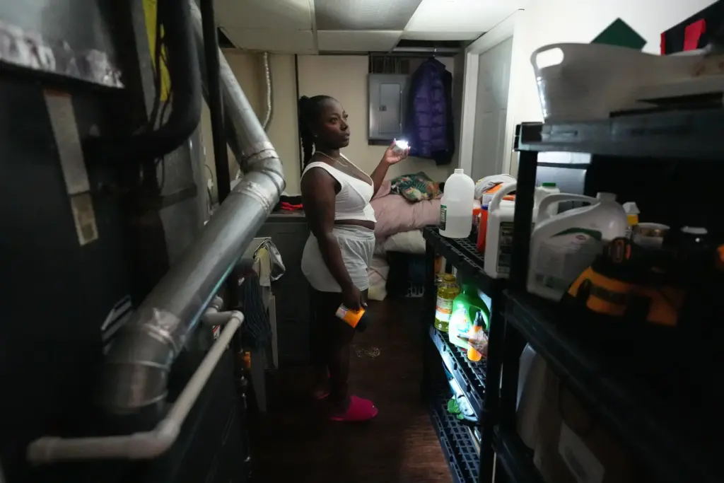 Shatiya Hardin uses a flashlight as she looks around her...