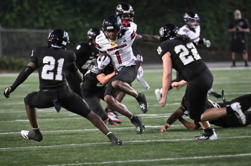 Centennialâs Quentin Hale (1) returns a punt as Servite moves...