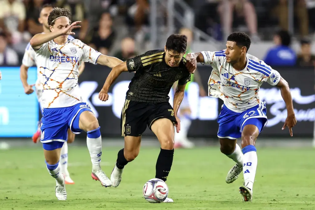 Los Angeles FC forward Son Heung-Min, center, is held by...