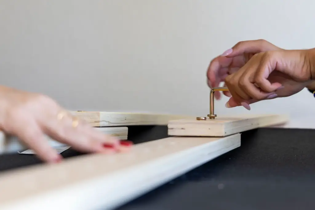 First year student Allison Agarwal screws in a nail for...