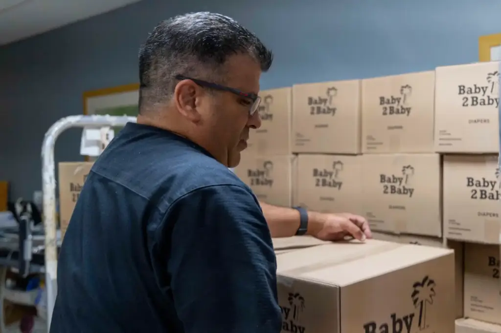 Lead Inventory Clerk David Fonseca unloads a cart of diapers...