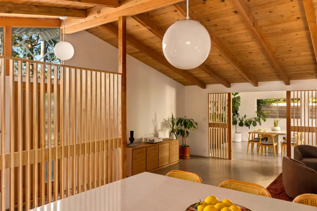 Wood-slat privacy screens define the entryway and the open archway...