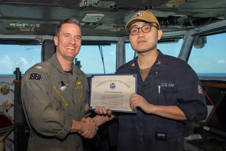 Electronics Technician Nuclear 2nd Class Jonathan Kim, right, receives a...