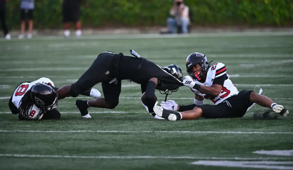 Serviteâs Benjamin Harris (6) holds onto the ball as Centennialâs...