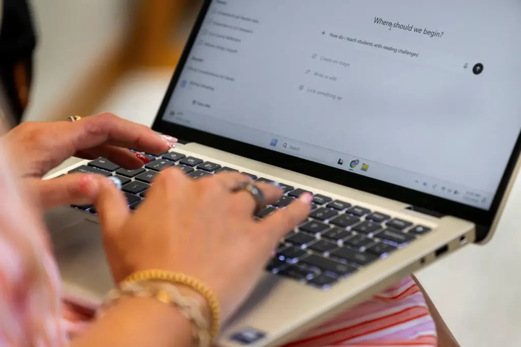 Preschool teacher Melissa Mowbray works with AI on her laptop...