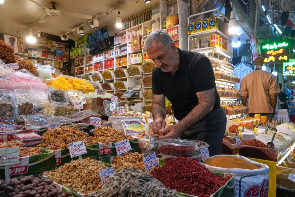 A shopkeeper arranges nuts at his shop at Tajrish traditional...