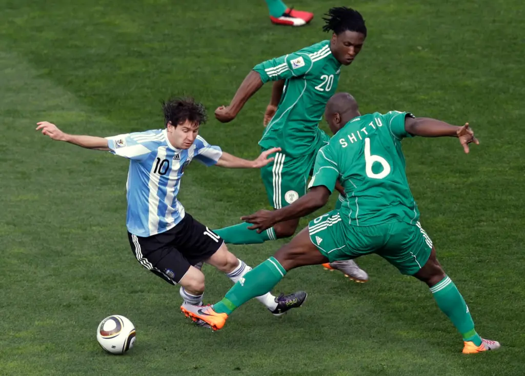 FILE – Argentina’s Lionel Messi, left, competes for the ball...