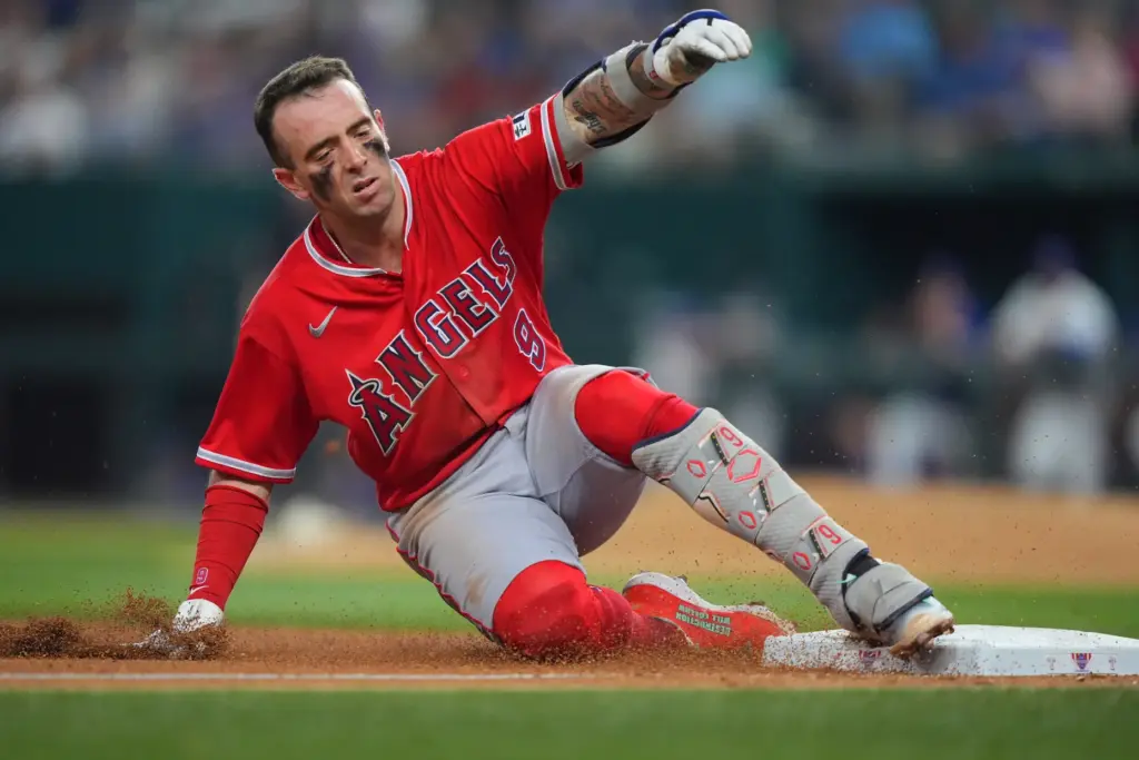Angels’ Zach Neto slides safely into third base for a...