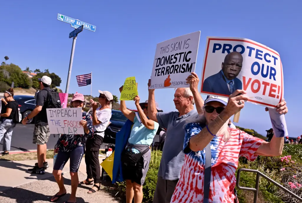 Protesters chant, and hold up signs against President Trump in...