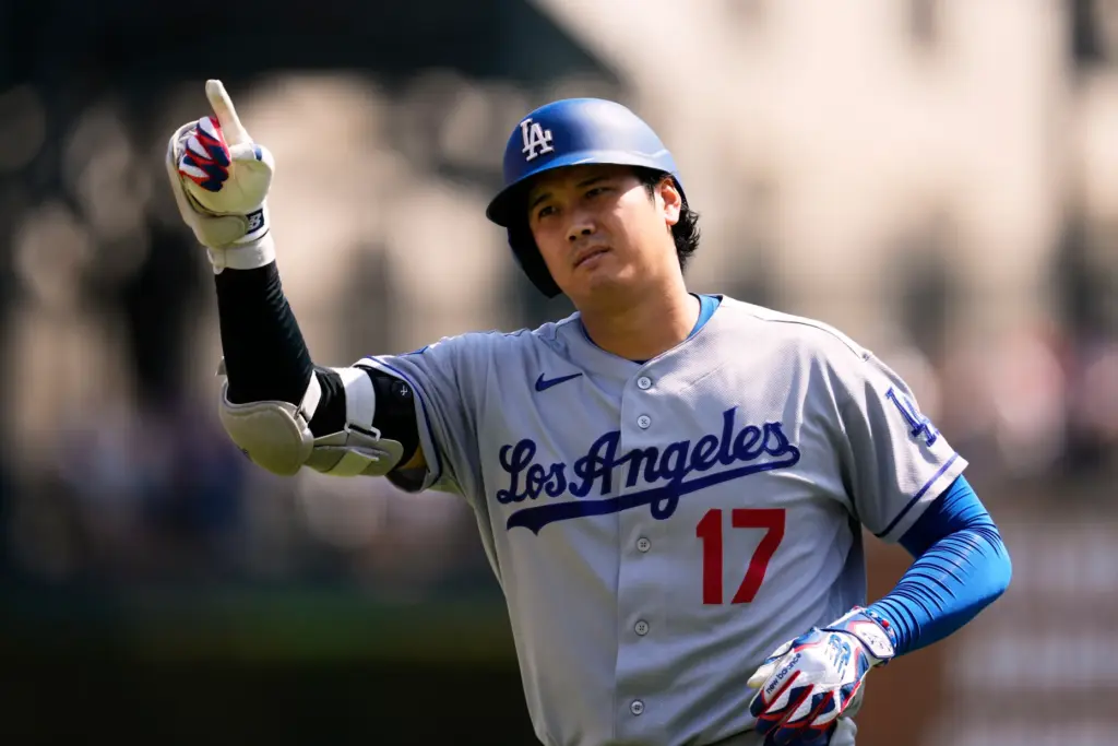 Dodgers’ player Shohei Ohtani signals to check the ruling on...