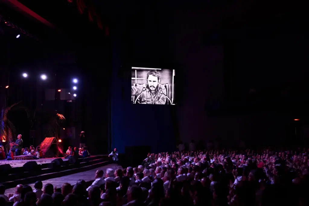 An image of Fidel Castro is displayed on a large...