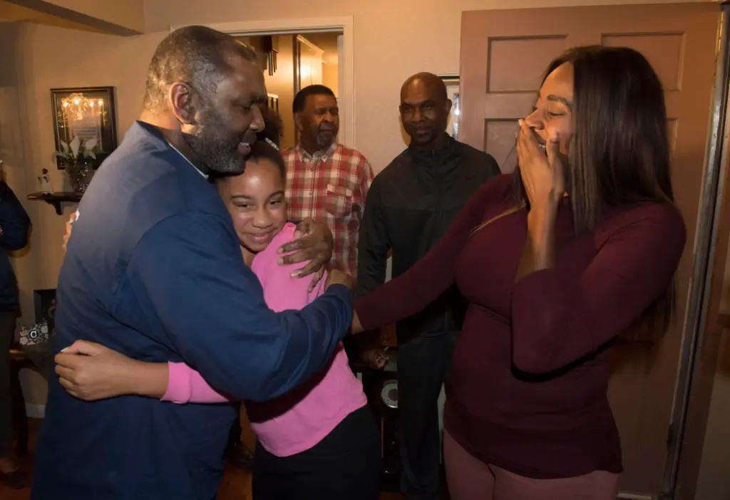 Guy Miles hugs his grand-niece Kayla, 11, as his niece...