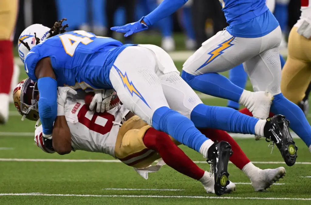 Chargers safety Kendall Williamson, top, tackles San Francisco 49ers safety...