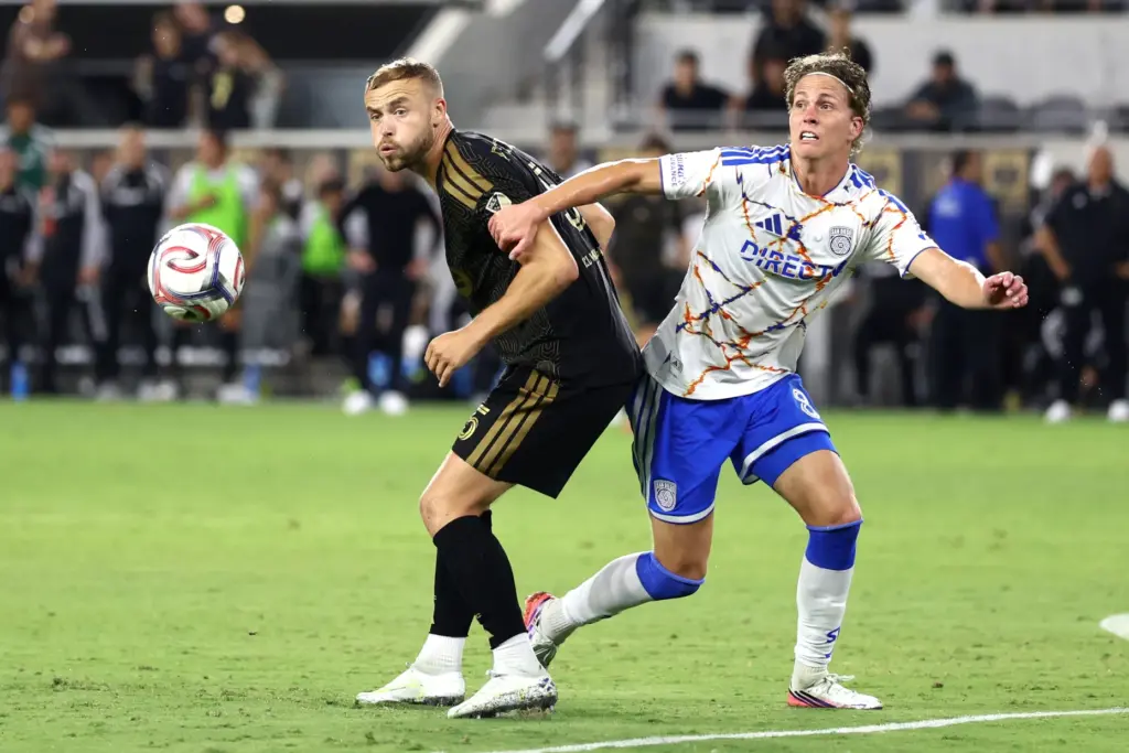 Los Angeles FC forward Ryan Porteous, left, is held by...