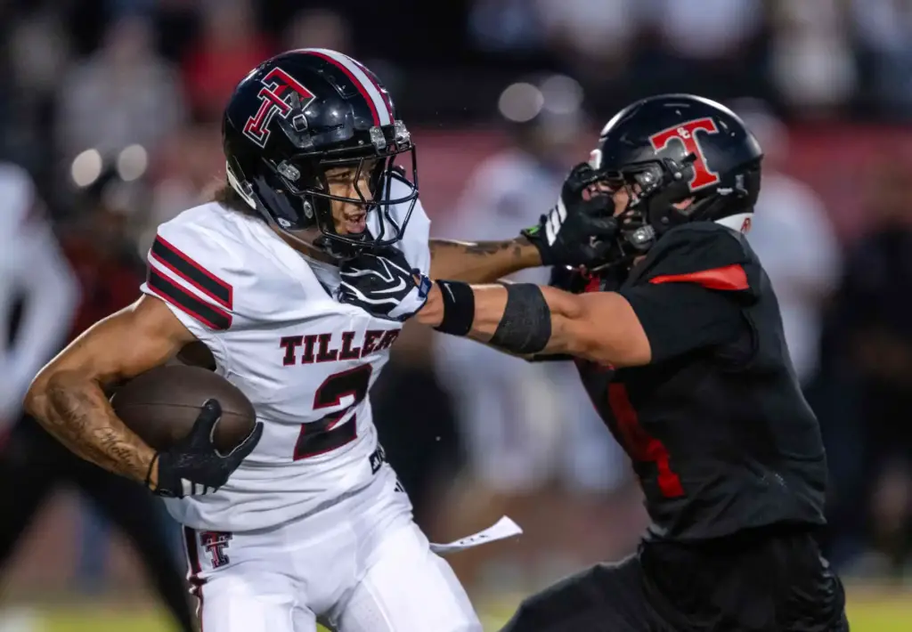 Tustin wide receiver Jeremiah Salvant (2), left, carries the ball,...