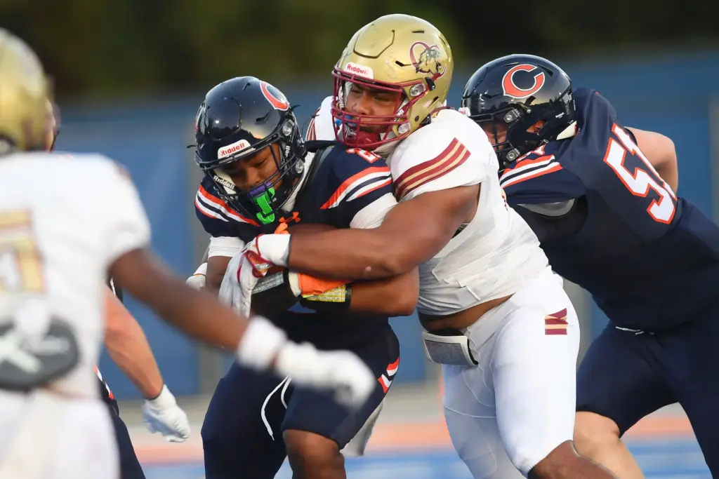 Chaminadeâs Shilo Beavers (20) is tackled by Oaks Christianâs Alifeleti...