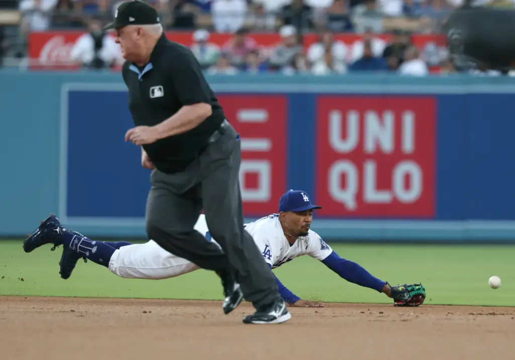 Dodgers shortstop Mookie Betts dives but can’t reach a ball...