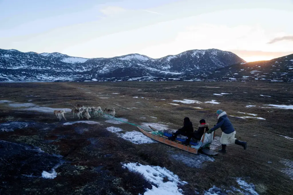 FILE – Jørgen Kristensen rides with his sled dogs in...