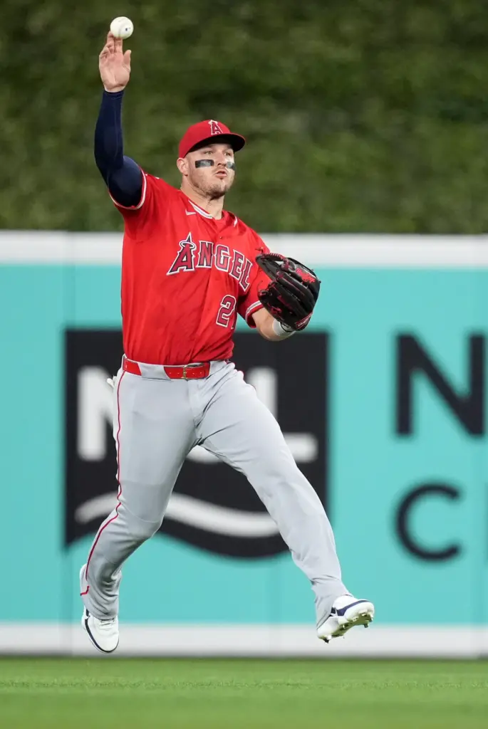 Angels center fielder Mike Trout fields a ball that was...